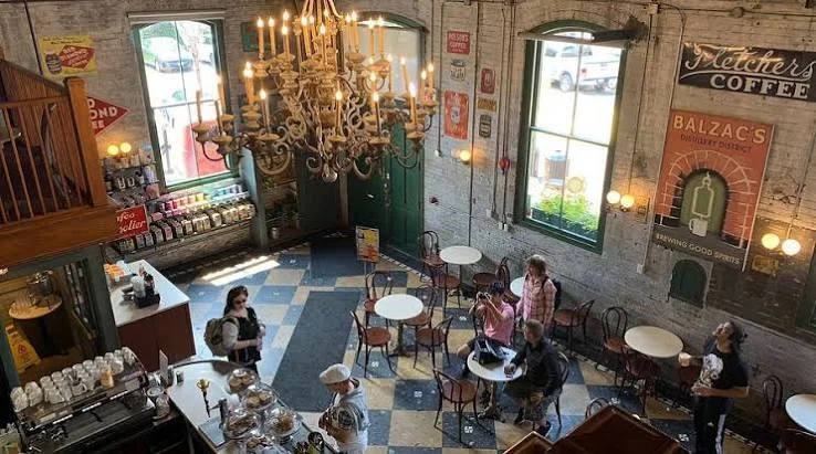 The room at Balzac's Coffee in the Distillery District, with a chandelier, checkerboard floor and exposed brick