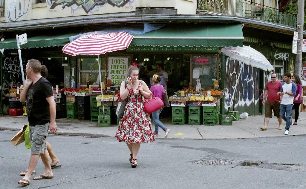 A market storefront with striped umbrellas and open fruit stands